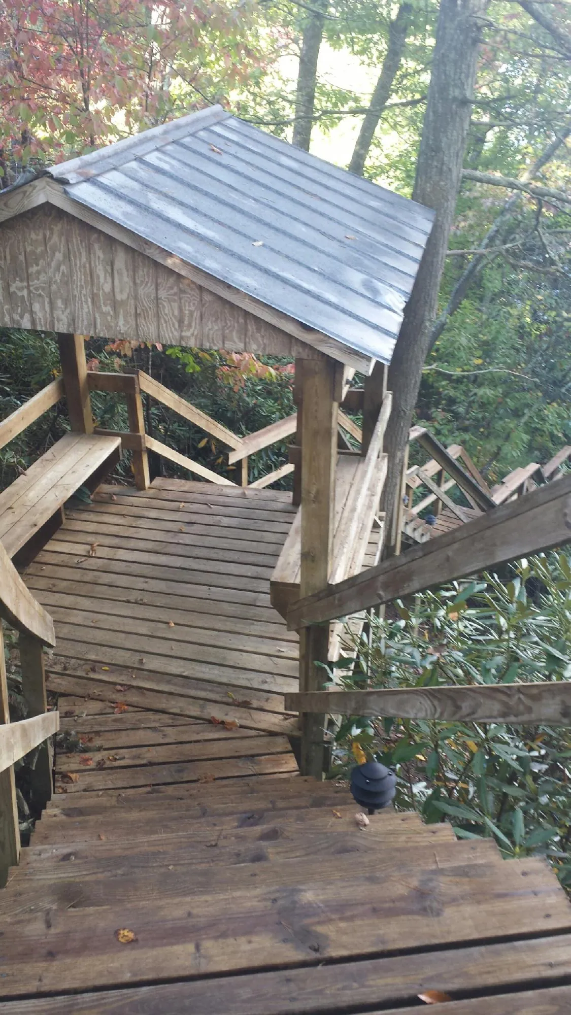 Metal roofed shelter over wooden steps on a wooded walkway — Skylight Repair & Installation work by our crew in Middlesex