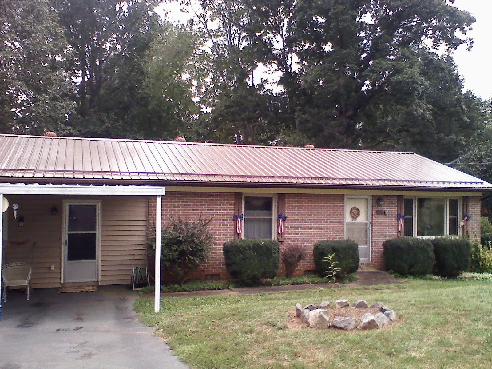 Bronze metal roof and carport on a brick ranch home — Roof Repair work by our crew in Middlesex